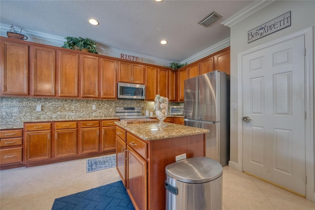 1454 Newhaven Point Ln, West Palm Beach, FL 33411 - kitchen featuring appliances with stainless steel finishes, light tile patterned floors, brown cabinetry, ornamental molding, and a textured ceiling