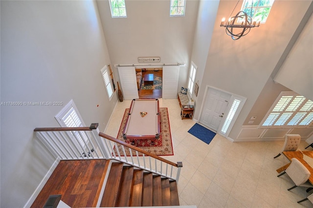 1454 Newhaven Point Ln, West Palm Beach, FL 33411 - entryway featuring a towering ceiling, healthy amount of natural light, a chandelier, tile patterned floors, and stairs