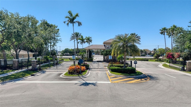 1454 Newhaven Point Ln, West Palm Beach, FL 33411 - view of asphalt road with a gate, curbs, and a gated entry