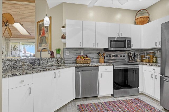 6121 SE Landing Way Unit 13, Stuart, FL 34997 - kitchen featuring appliances with stainless steel finishes, dark stone counters, a sink, tasteful backsplash, and white cabinetry