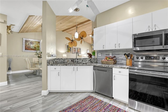 6121 SE Landing Way Unit 13, Stuart, FL 34997 - kitchen featuring stainless steel appliances, a sink, dark stone countertops, white cabinetry, and baseboards