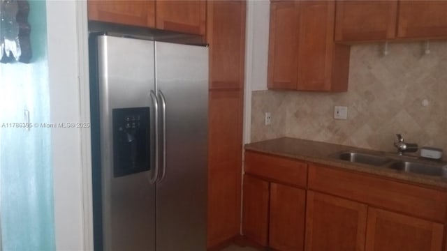 1950 Biarritz Dr Unit 1, Miami Beach, FL 33141 - kitchen with stainless steel fridge with ice dispenser, a sink, tasteful backsplash, brown cabinetry, and light countertops