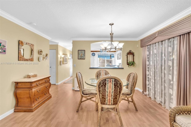 14898 Wildflower Ln Unit 0, Delray Beach, FL 33446 - dining room featuring light wood-style floors, a chandelier, ornamental molding, a textured ceiling, and baseboards