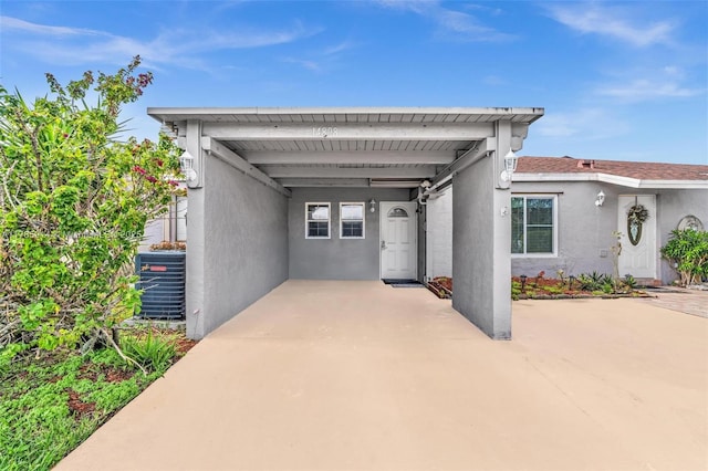 14898 Wildflower Ln Unit 0, Delray Beach, FL 33446 - view of front of property with stucco siding, an attached carport, cooling unit, and driveway