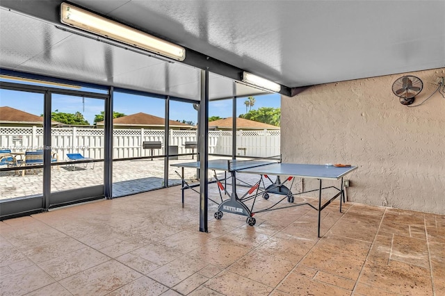 14898 Wildflower Ln Unit 0, Delray Beach, FL 33446 - recreation room with a textured wall, stone tile flooring, and expansive windows