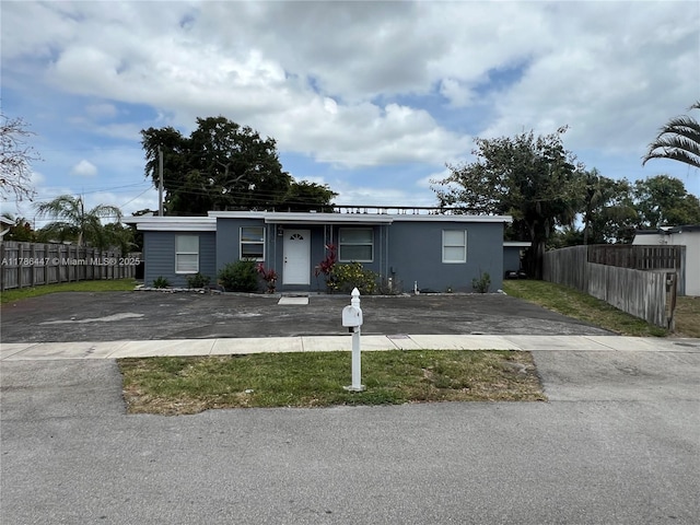 single story home with stucco siding, aphalt driveway, and fence