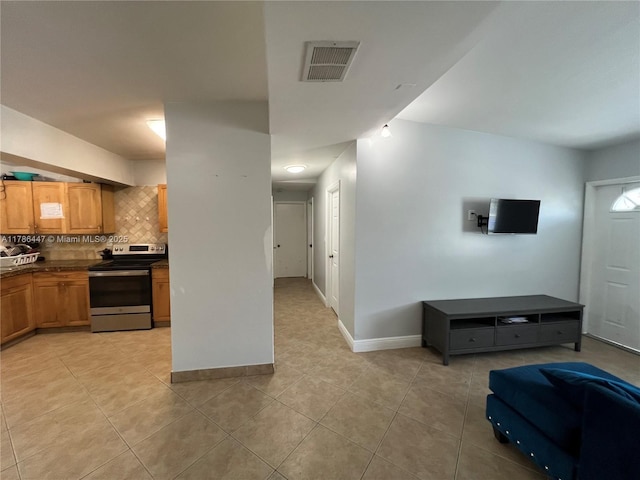 kitchen featuring backsplash, dark countertops, electric stove, visible vents, and light tile patterned flooring