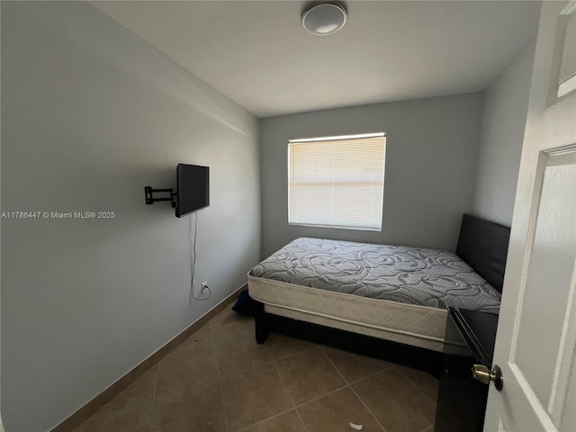 tiled bedroom featuring baseboards
