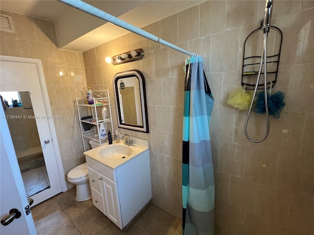 full bathroom featuring tile walls, tile patterned floors, vanity, and tiled shower