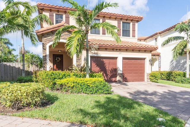 102 NE 23rd Ter, Homestead, FL 33033 - mediterranean / spanish-style house with a tile roof, driveway, fence, an attached garage, and stucco siding
