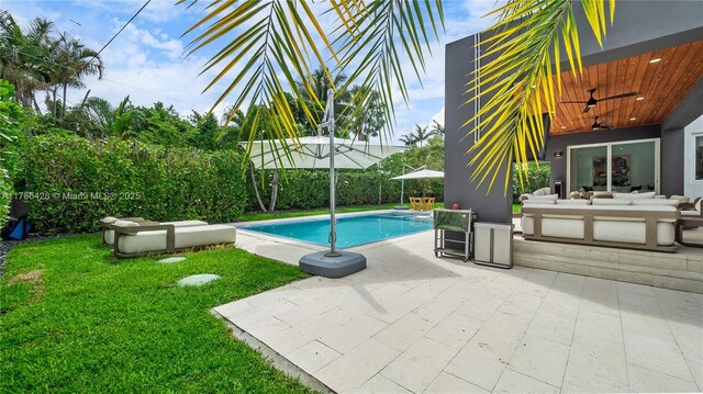 10603 NE 11th Ave, Miami Shores, FL 33138 - view of swimming pool with outdoor lounge area, ceiling fan, a lawn, and a patio area