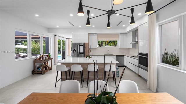 10603 NE 11th Ave, Miami Shores, FL 33138 - kitchen featuring modern cabinets, stainless steel appliances, light tile patterned flooring, white cabinets, and recessed lighting