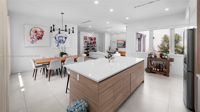 10603 NE 11th Ave, Miami Shores, FL 33138 - kitchen with modern cabinets, a spacious island, light tile patterned floors, recessed lighting, and light countertops