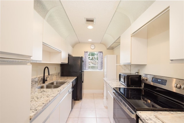 13940 Nesting Way Unit C, Delray Beach, FL 33484 - kitchen featuring stainless steel range with electric cooktop, black microwave, white cabinetry, light tile patterned flooring, and light stone counters