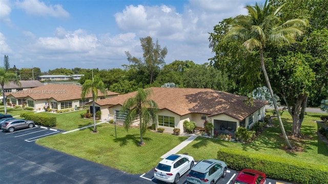 13940 Nesting Way Unit C, Delray Beach, FL 33484 - view of front of home featuring uncovered parking, stucco siding, and a front lawn