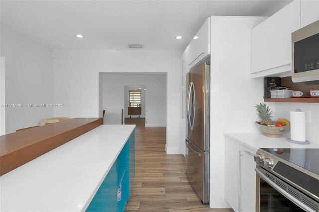 3953 SW 60th Ave, Miami, FL 33155 - kitchen featuring appliances with stainless steel finishes, white cabinets, recessed lighting, light wood-type flooring, and light countertops