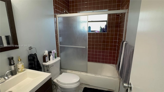 full bath featuring combined bath / shower with glass door, toilet, and vanity
