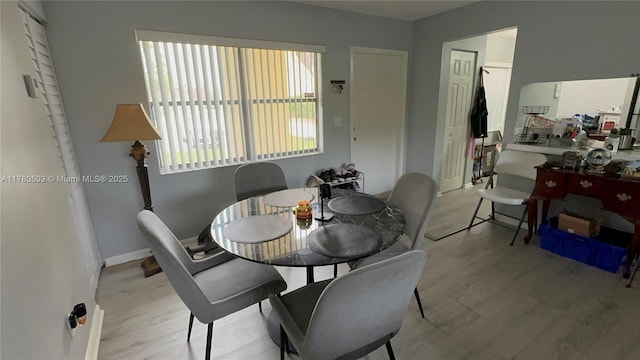 dining space featuring wood finished floors and baseboards
