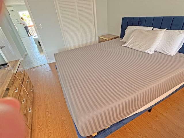 bedroom featuring baseboards, a closet, and wood finished floors