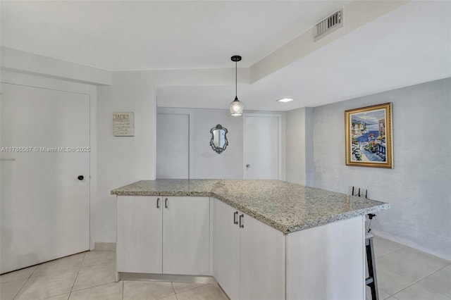 3000 Holiday Dr Unit 306, Fort Lauderdale, FL 33316 - kitchen featuring light stone counters, light tile patterned floors, baseboards, decorative light fixtures, and a peninsula
