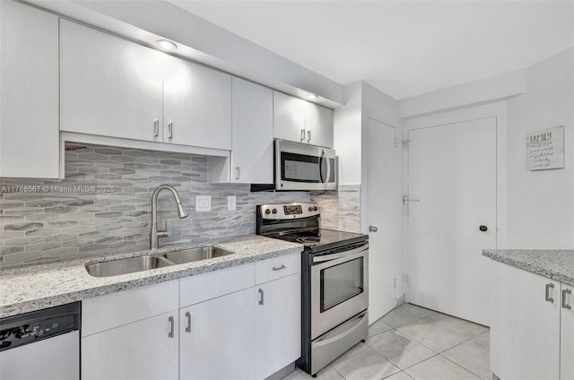 3000 Holiday Dr Unit 306, Fort Lauderdale, FL 33316 - kitchen with appliances with stainless steel finishes, a sink, backsplash, and light stone countertops