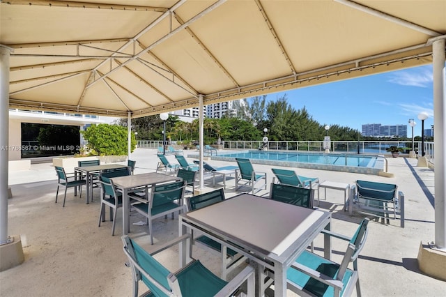 3000 Holiday Dr Unit 306, Fort Lauderdale, FL 33316 - view of patio featuring a gazebo, a community pool, fence, and outdoor dining space