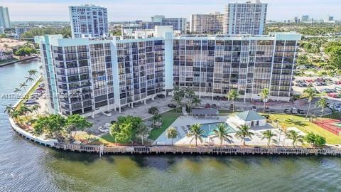view of building exterior featuring a water view and a city view