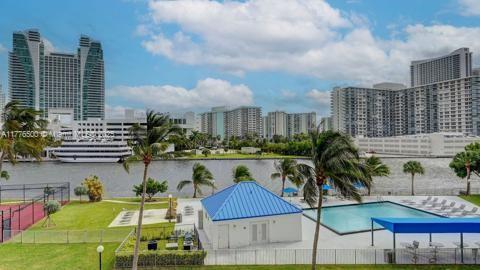 community pool featuring a view of skyline, fence, and a water view