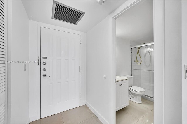 bathroom featuring tile patterned floors, a shower stall, vanity, and toilet