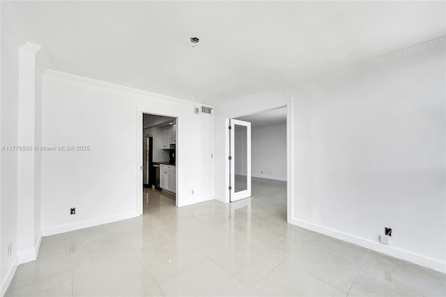empty room featuring baseboards, crown molding, light tile patterned floors, and fire sprinkler in ceiling