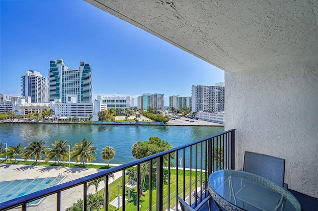 balcony featuring a water view and a skyline view