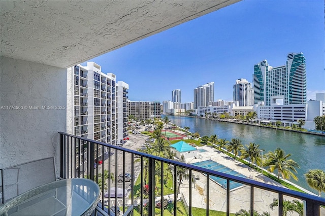 balcony featuring a water view and a skyline view