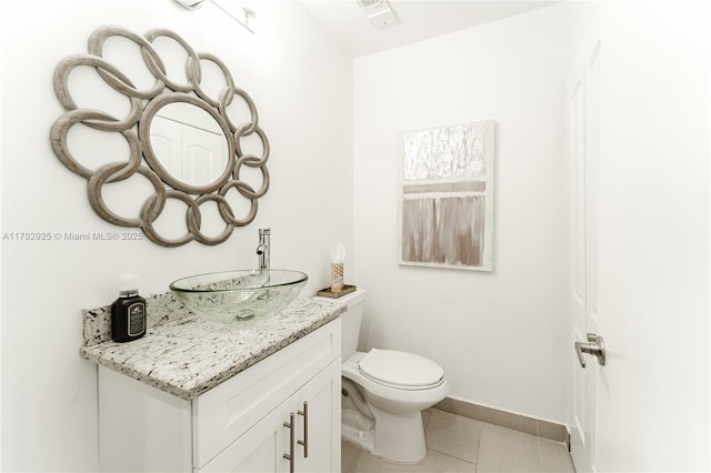 bathroom with toilet, tile patterned floors, vanity, baseboards, and visible vents