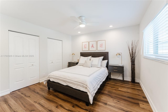 bedroom with a ceiling fan, wood finished floors, multiple closets, baseboards, and recessed lighting