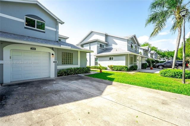 view of front of property with a garage, driveway, a front yard, and stucco siding