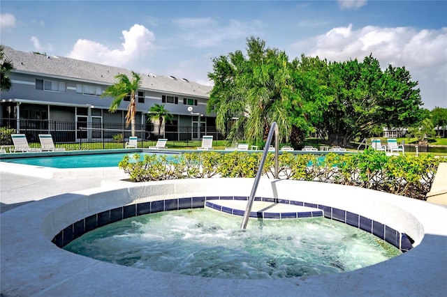 community pool with fence and a community hot tub