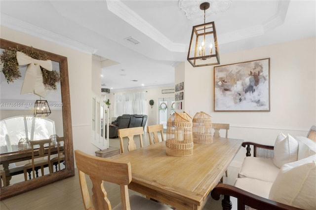 dining area with light tile patterned flooring, visible vents, a chandelier, and crown molding