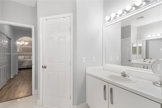 full bath with tile patterned floors, ensuite bathroom, visible vents, a chandelier, and vanity
