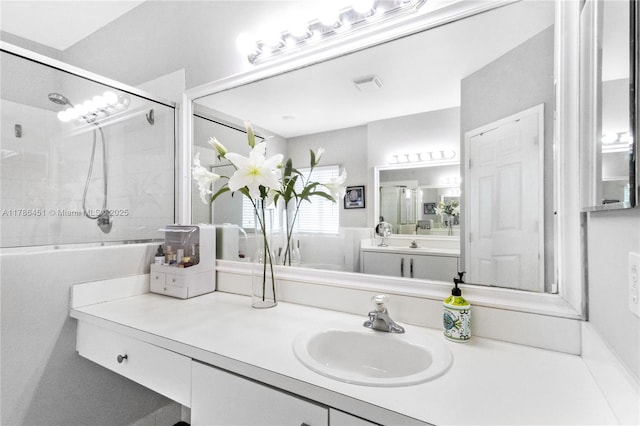 full bath featuring vanity, a shower with door, and visible vents