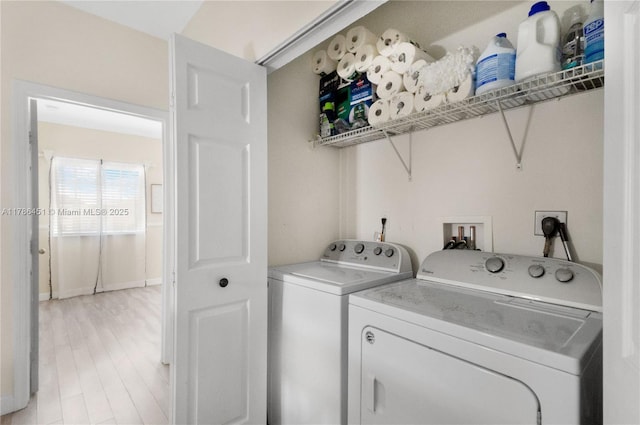 clothes washing area featuring washer and clothes dryer, laundry area, and light wood-type flooring