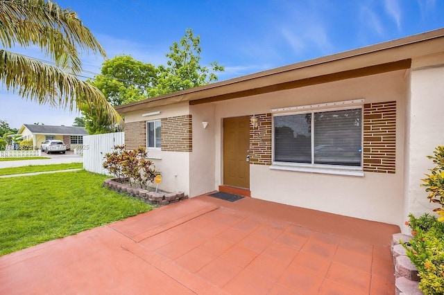 6200 Wiley St, Hollywood, FL 33023 - view of front of property with stucco siding, a front lawn, brick siding, and a patio