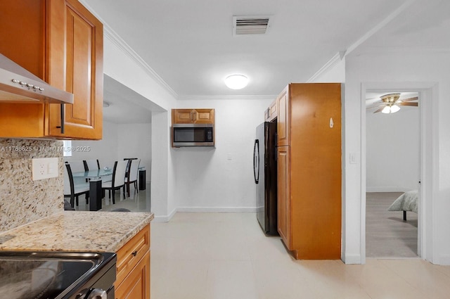 6200 Wiley St, Hollywood, FL 33023 - kitchen with stainless steel microwave, backsplash, ornamental molding, visible vents, and freestanding refrigerator