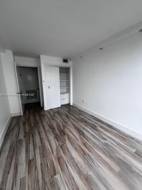 600 NE 36th St Unit 1706, Miami, FL 33137 - unfurnished bedroom featuring wood finished floors, baseboards, and a closet
