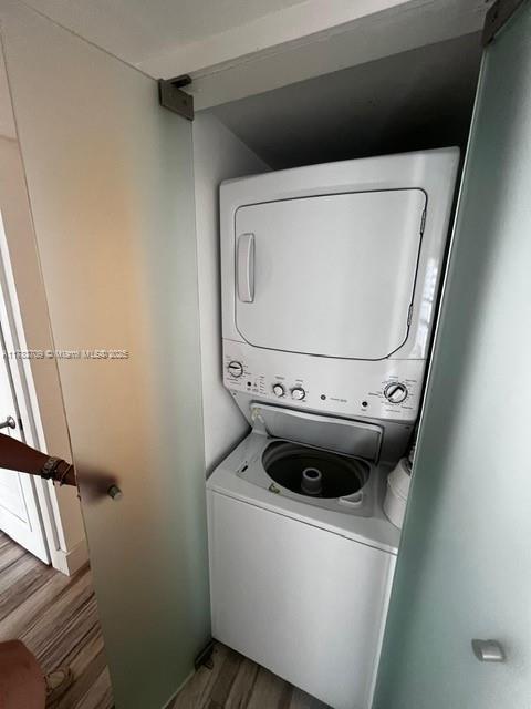 600 NE 36th St Unit 1706, Miami, FL 33137 - washroom with stacked washer and clothes dryer and wood finished floors