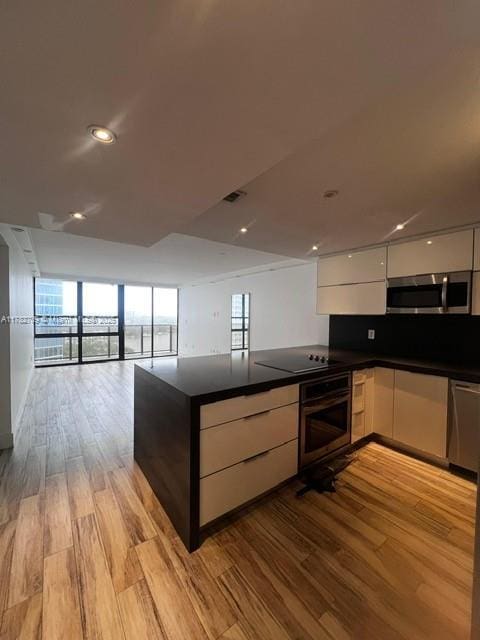 600 NE 36th St Unit 1706, Miami, FL 33137 - kitchen featuring appliances with stainless steel finishes, modern cabinets, white cabinets, dark countertops, and recessed lighting