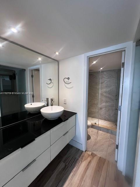 600 NE 36th St Unit 1706, Miami, FL 33137 - full bathroom featuring double vanity, a stall shower, wood finished floors, recessed lighting, and toilet