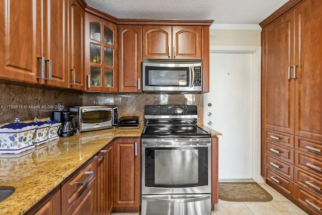 844 SW 134th Pl, Miami, FL 33184 - kitchen featuring a toaster, stainless steel appliances, light stone countertops, decorative backsplash, and glass insert cabinets