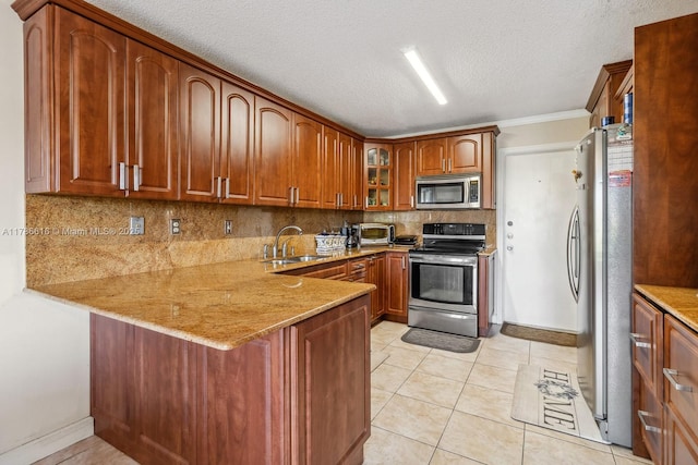 844 SW 134th Pl, Miami, FL 33184 - kitchen with a textured ceiling, decorative backsplash, glass insert cabinets, a peninsula, and appliances with stainless steel finishes