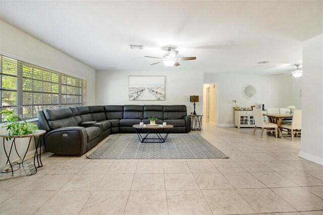 living area with baseboards, a ceiling fan, visible vents, and light tile patterned floors