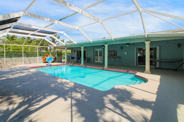 outdoor pool featuring a patio area, glass enclosure, ceiling fan, and french doors